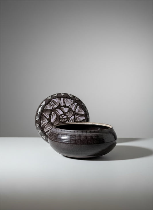 Black glazed ceramic bowl with hand-carved floral relief disc lid